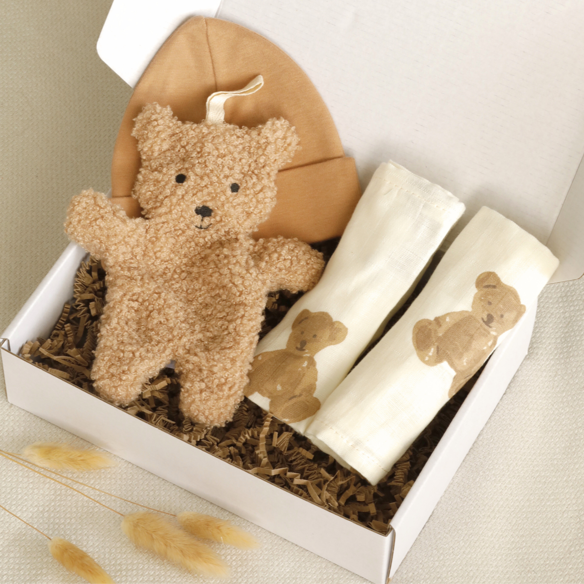Die neutrale Geschenkbox Kleiner Bär wurde mit viel Liebe für kleine Mädchen und Jungen zusammengestellt. Sie enthält hochwertige, aufeinander abgestimmte Produkte in warmen Beige- und Brauntönen – ein Schmusetuch aus weichem Bouclé-Stoff, Spucktücher mit süßen Bärchenmotiven und eine Babymütze aus Baumwolle.&nbsp;