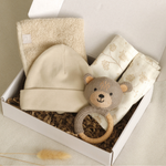 Liebevoll zusammengestellte neutrale Geschenkbox Sand Stern für Mädchen und Jungen: weiche Spucktücher, Bouclé-Rassel, Lätzchen und süße Mütze mit optionalem Namensplott. Harmonische Beige- und Taupetöne – das perfekte Geschenk zur Geburt